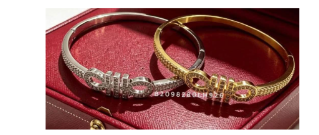 Infinity Loop Crystal Armbänder in Silber und Gold mit klaren Steinen auf rotem Schmuckkästchen